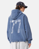 model wearing blue washed 77 graphic hoodie back view