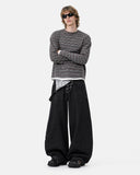 model styling dark gray striped long sleeve tee with baggy overalls