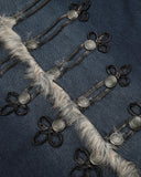 ornate button and loop closure detail on denim jacket close-up