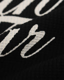 distressed calligraphy lettering close up on black waffle t shirt