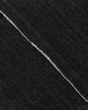 black denim raw edge seam detail close-up