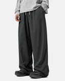 Side view of dark gray wide leg pants showing relaxed fit and tapered leg