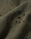 Close-up of the faded vintage wash texture and hand-distressed hole accents on linen-blend.