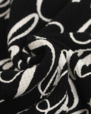 script graphic print detail on textured black fabric