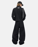 back outfit view with black boxy polo and baggy pants