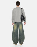 model wearing dirty blue barrel jeans back view