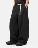 Detail view of drawstring waist and pocket construction on wide leg pants