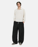 Model wearing cream long sleeve polo and black cordura nylon wide leg pants
