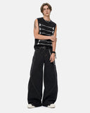model wearing black embroidered knit tank top with barrel jeans