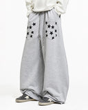 model wearing grey barrel sweatpants with star pocket details