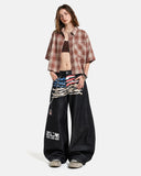 model wearing black barrel jeans with plaid shirts relaxed outfit view